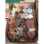 A tray containing an assortment of collectible items to include embroidered badges, binoculars, tape