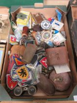 A tray containing an assortment of collectible items to include embroidered badges, binoculars, tape