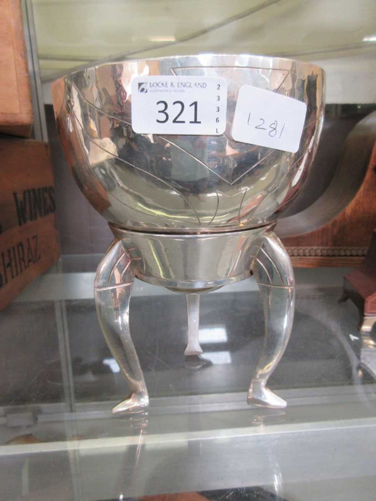 A silver plated bowl on three legged stand