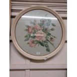 A circular framed needlework of roses