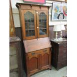 An early 20th century oak bureau bookcase, the top with glazed door over the fall front with