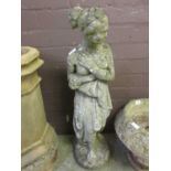 A composite stone garden ornament in the form of a scantily clad lady