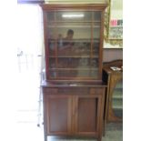 An early 20th century mahogany bookcase with single glazed door on a base with three drawers and two