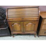 An early 20th cylindrical oak bureau with part fitted interior and two cupboard doors to base