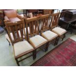 A set of four mid-20th century oak high back dining chairs with drop in seats