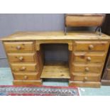 A waxed pine desk having twin pedestals of four drawers