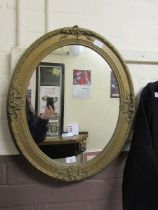 A gilt painted oval wall mirror