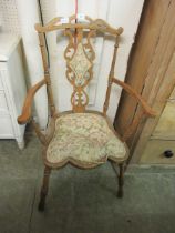 An early 20th century beech open armchair having overstuffed pads to back and seat
