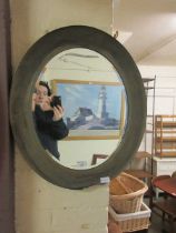 An oval framed bevel glass wall mirror (A/F) Large chip to bottom of frame.