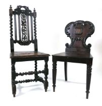 A regency mahogany hall chair, the shaped back carved with scrolls framing a recessed shield