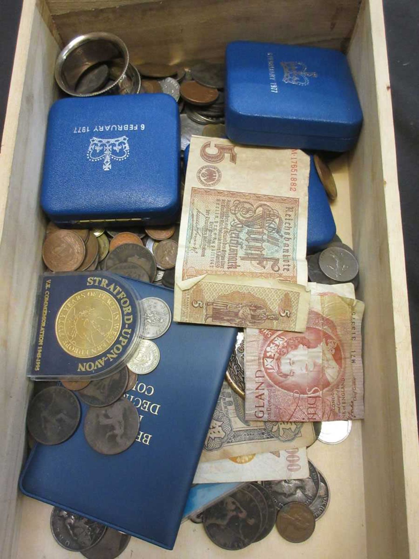 A wooden box containing a quantity of coinage, paper notes, etc