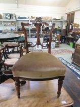 An early 20th century walnut framed bedroom chair having overstuffed seat