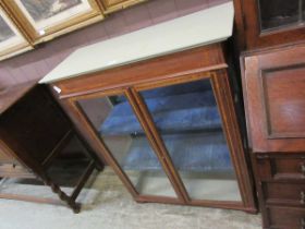 A mahogany inlaid two door glazed cabinet having a painted top