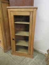 A waxed pine and glazed door music cabinet