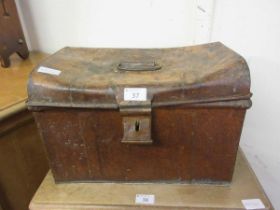 A small metal dome topped tin trunk