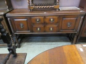 An oak sideboard with two cupboards and two drawers on turned supports