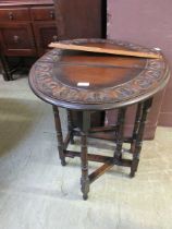 A carved oak oval drop leaf gate leg table