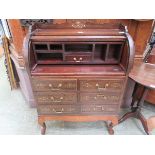 A reproduction mahogany and brass inlaid roll top desk on cabriole supports