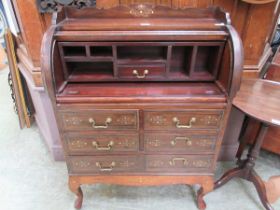 A reproduction mahogany and brass inlaid roll top desk on cabriole supports