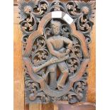 A carved wooden Indian panel depicting a musician measuring 30cm x 45cm