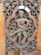 A carved wooden Indian panel depicting a musician measuring 30cm x 45cm