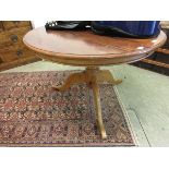 A reproduction stained pine circular breakfast table