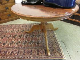 A reproduction stained pine circular breakfast table