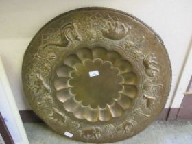 An embossed circular brass tray