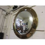 A circular convex brass framed mirror