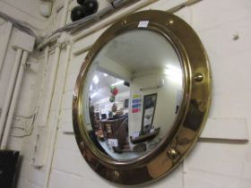 A circular convex brass framed mirror