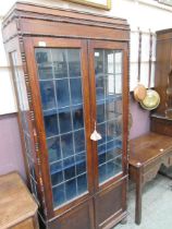 An oak and glazed double door display cabinet