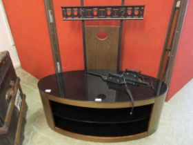 A modern mid-20th century style dark wood and glass TV stand