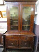 An oak sideboard on turned supports together with a glazed double door bookcase