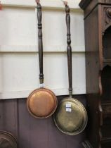 A brass warming pan and a small reproduction copper warming pan