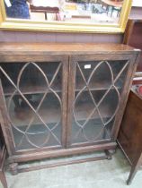 An oak and glazed double door display cabinet