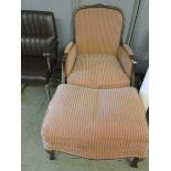 A reproduction carved and stained beech easy chair with matching footstool upholstered in a