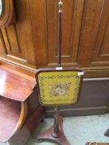 A Victorian mahogany fire screen with later embroidered panel