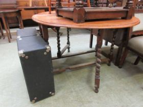 An oak oval drop leaf dining table on barley twist supports