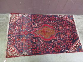 A woollen red and blue ground rug
