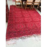 A Turkoman style red carpet Fringe appears to have been damaged on one side. Tape to back of rug,
