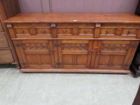 A high quality mid-20th century Titchmarsh and Goodwin oak sideboard having three drawers above