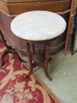 A circular marble topped walnut table