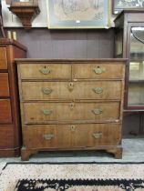 An early Victorian walnut veneered chest of two short over three long graduating drawers on