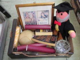 A tray containing a knitted doll, posters, books, etc