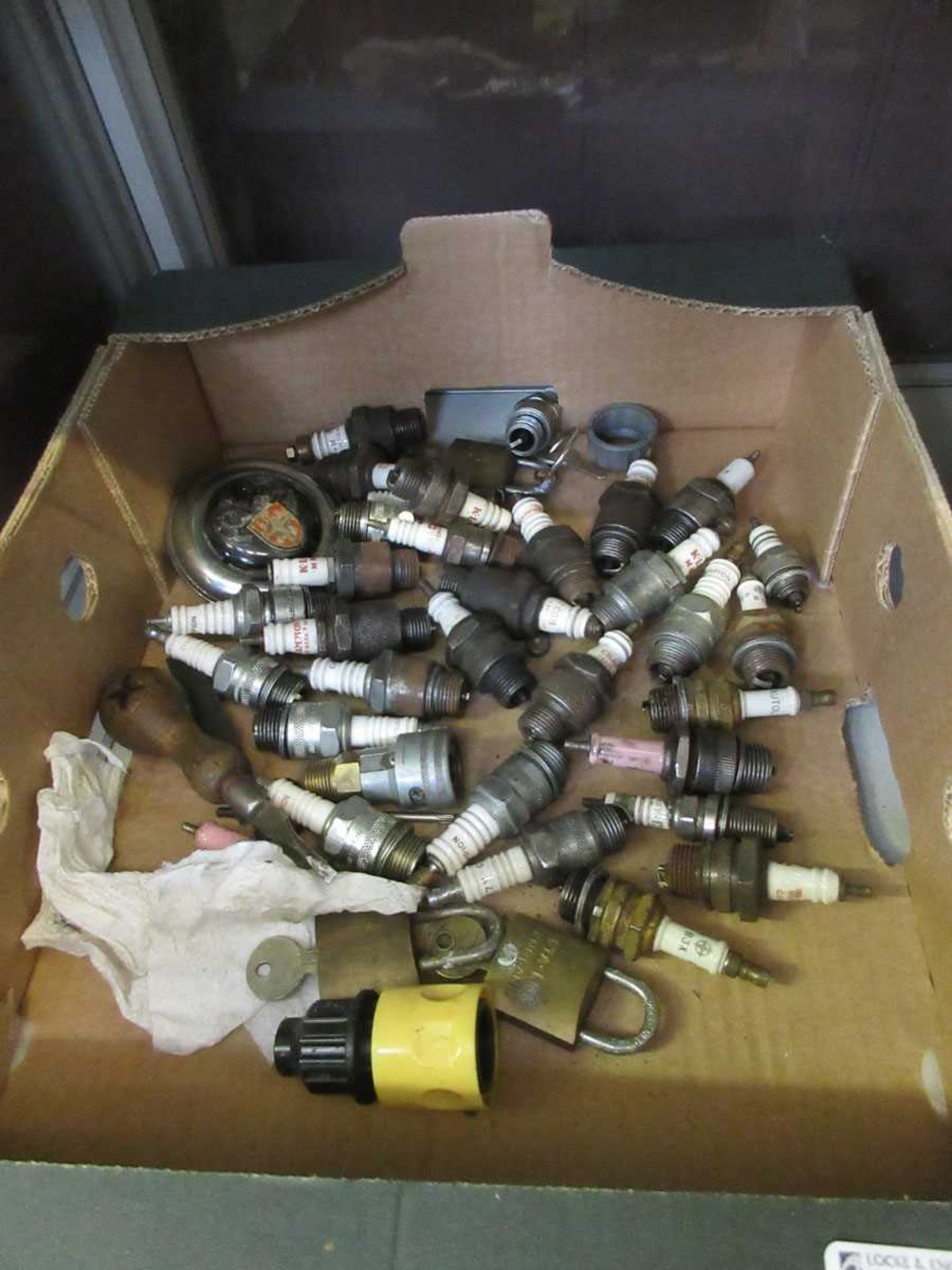 A box containing a quantity of used spark plugs