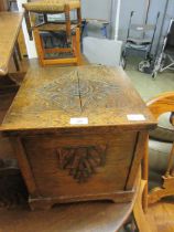 An early 20th century carved oak hinge top coal box