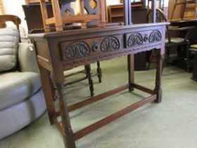 A reproduction oak cabinet with 2 carved drawers