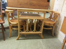 A bamboo table with glass top with a pair of matching chairs