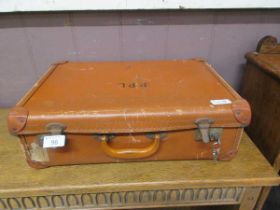 A brown canvas suitcase initialled R.P.L