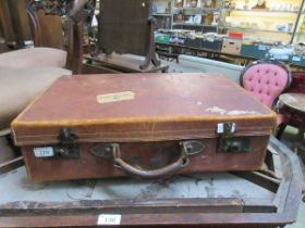 A distressed tanned leather suitcase